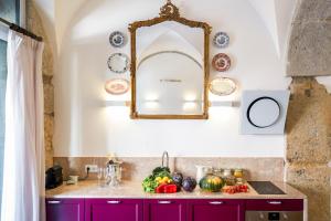 een keuken met paarse kasten en een spiegel aan de muur bij Residentas Apostolos in Lissabon
