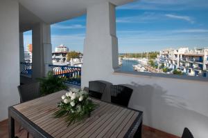 drewniany stół z wazą kwiatów na balkonie w obiekcie Portoverde Beach Apartments w mieście Misano Adriatico