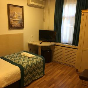 um quarto de hotel com uma cama, uma secretária e uma janela em Gul Hotel em Istambul