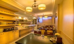 a large kitchen with wooden cabinets and a table at Gul Hotel in Istanbul