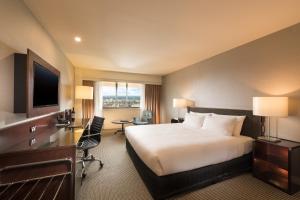 アデレードにあるスタンフォード プラザ アデレードのベッドとデスクが備わるホテルルームです。