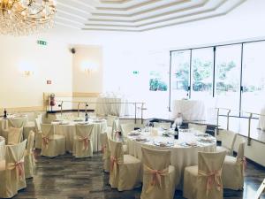 a room with tables and chairs with white tablecloths at Hotel Bel Sit in Comerio
