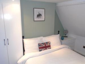 Dormitorio con cama con almohada de bandera británica en Kenilworth Cosy Castle View Apartment, en Kenilworth