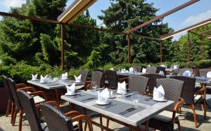 - un ensemble de tables et de chaises sur une terrasse dans l'établissement Ensana Thermal Sárvár, à Sárvár