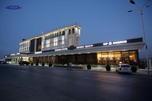 a building on the side of a street at night at Parliament Palace Hotel in Khujand