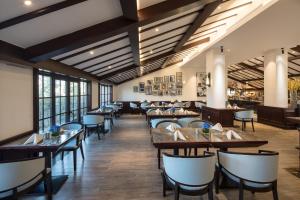 - une salle à manger avec des tables, des chaises et des fenêtres dans l'établissement Yiwu Kasion Purey Hotel, à Yiwu