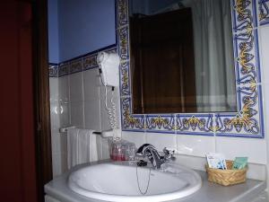 uma casa de banho com um lavatório branco e um espelho. em Casa Grande de El Burgo em El Burgo