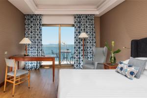 a hotel room with a bed and a desk and a table at Hotel Royal Continental in Naples