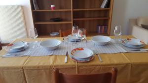 a table with plates and wine glasses on it at Via Monte Grappa,63 Alloggio Silenzioso a Barbisano in Collalto +6 photos