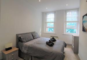 a bedroom with a bed with two teddy bears on it at Spacious Central Chic Apartment - Simply Check In in Winchester