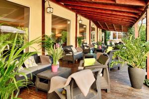 patio z krzesłami, stołami i roślinami w obiekcie Falenty Biznes i Wypoczynek w Raszynie
