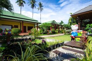 a garden with a hello kitty statue in front of a house at Sleep In Lanta Resort in Ko Lanta