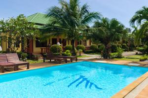 a pool in front of a house with palm trees at Sleep In Lanta Resort in Ko Lanta