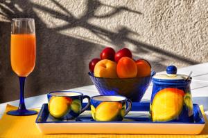 a tray with a bowl of fruit and a glass of orange juice at Mansarda sopra il mare in San Marco dʼAlunzio +4 photos