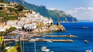 a town on a hill with boats in the water at Appartamento Raffaella in Pimonte