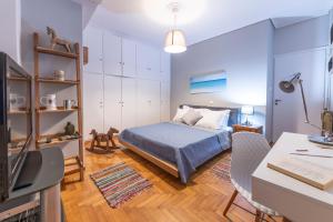 a small bedroom with a bed and a desk at Piraeus Port Marouso in Piraeus