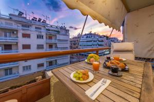 Una mesa con comida y bebidas en un balcón. en Piraeus Port Marouso, en Pireo