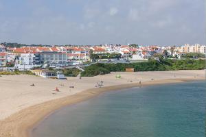 un grupo de personas en una playa cerca del agua en Cerca da Vitoria 3 Milfontes, en Vila Nova de Milfontes