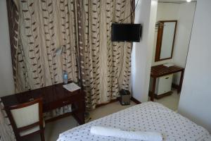 a bedroom with a bed and a desk and a mirror at Florida Executive Inn in Dar es Salaam