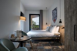 a bedroom with a bed, chair and a window at SOWELL HOTELS Les Chevaliers in Carcassonne