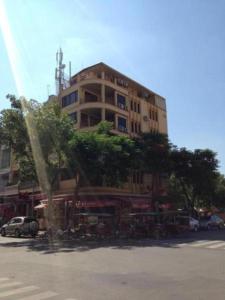 un grand bâtiment avec un arbre devant lui dans l'établissement The Bright Lotus Guesthouse, à Phnom Penh
