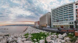 a group of buildings next to a body of water at Hotel Royal Continental in Naples