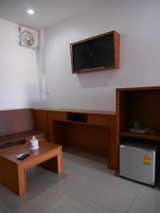 a living room with a flat screen tv on the wall at Paradise Hotel in Kanchanaburi