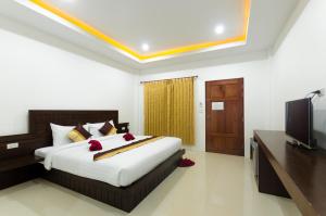 a bedroom with a bed and a flat screen tv at Sleep In Lanta Resort in Ko Lanta