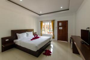 a bedroom with a bed with a red bow on it at Sleep In Lanta Resort in Ko Lanta