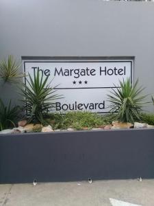 ein Schild für das Marrakesch-Hotel hinter Pflanzen in der Unterkunft Margate Boulevard 302 in Margate