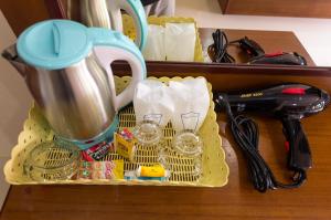 a container with a tea pot and glasses on a table at Sleep In Lanta Resort in Ko Lanta