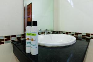 a bathroom with a sink and a bottle of sunscreen at Sleep In Lanta Resort in Ko Lanta