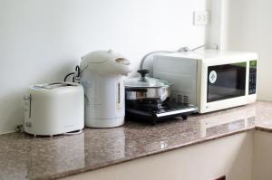 a kitchen counter with a toaster and a microwave at Sleep In Lanta Resort in Ko Lanta
