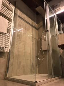La salle de bains est pourvue d'une douche avec une porte en verre. dans l'établissement Moderno affaccio su via Mazzini, à Ferrare