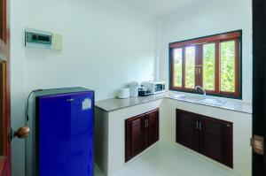 a kitchen with a blue refrigerator and a sink at Sleep In Lanta Resort in Ko Lanta
