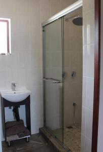 een badkamer met een glazen douche en een wastafel bij Misty Cottage in Dullstroom