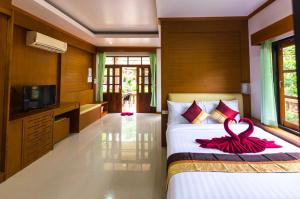 a bedroom with a bed with a red ribbon on it at Sleep In Lanta Resort in Ko Lanta