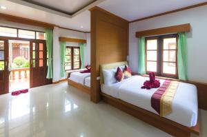 a bedroom with two beds in a room with windows at Sleep In Lanta Resort in Ko Lanta