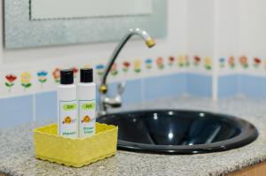 a bathroom counter with a sink and a bottle of sunscreen at Sleep In Lanta Resort in Ko Lanta