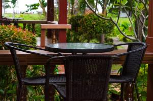 a glass table and two chairs on a patio at Sleep In Lanta Resort in Ko Lanta