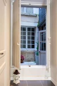 ein offenes Fenster mit Blick auf ein Haus in der Unterkunft Le Relais Du Petit Lion in Blois