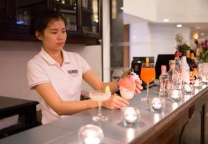 チェンマイにあるCH Hotelのカクテルを作るバーに立つ女性 +65枚の写真