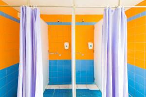 ein Badezimmer mit blauen und orangefarbenen Wänden und Duschvorhängen in der Unterkunft Hostel Brize in Liepāja