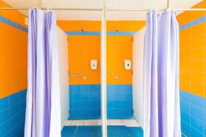 a bathroom with blue and orange walls and shower curtains at Hostel Brize in Liepāja