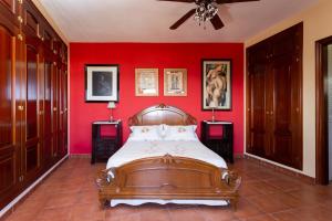 1 dormitorio con 1 cama en una pared roja en Casa Bora en Casas de Abajo