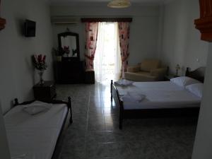 a bedroom with two beds and a living room at Hotel Villa Basil in Tsilivi