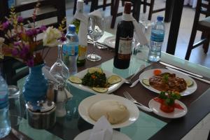 una mesa con platos de comida y botellas de vino en Florida Executive Inn en Dar es Salaam