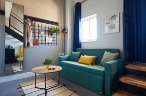 a living room with a blue couch and a table at The Post Hostel Jerusalem in Jerusalem