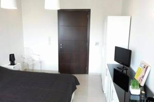 a bedroom with a bed and a television in it at Heart City Executive Suite in Chania