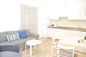 a living room with a couch and a table and a kitchen at Apartamentos El Marinero - Roque in Caleta de Sebo